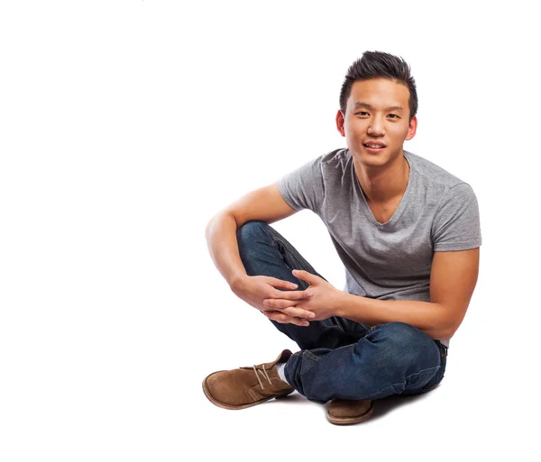 Young asian man sitting on floor — Stock Photo, Image