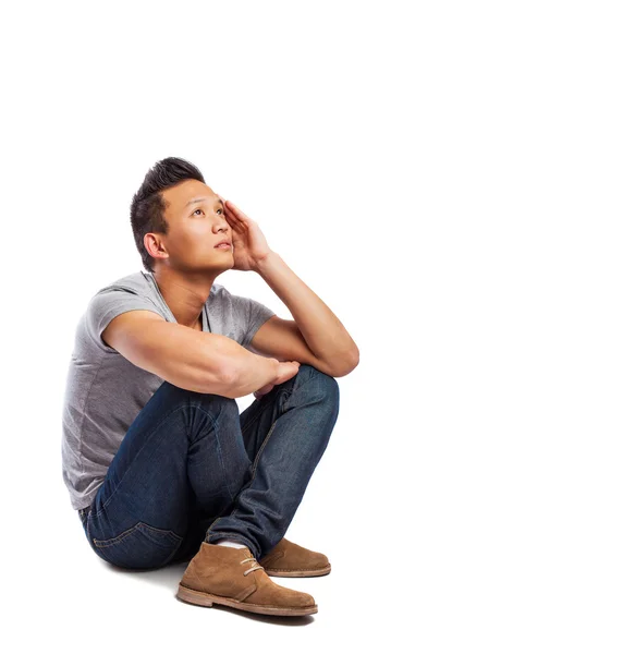 Young asian man sitting on floor — Stock Photo, Image