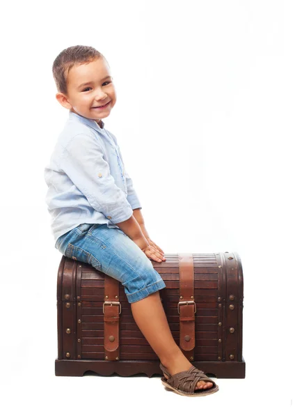 Niño sentado en un baúl de madera — Foto de Stock