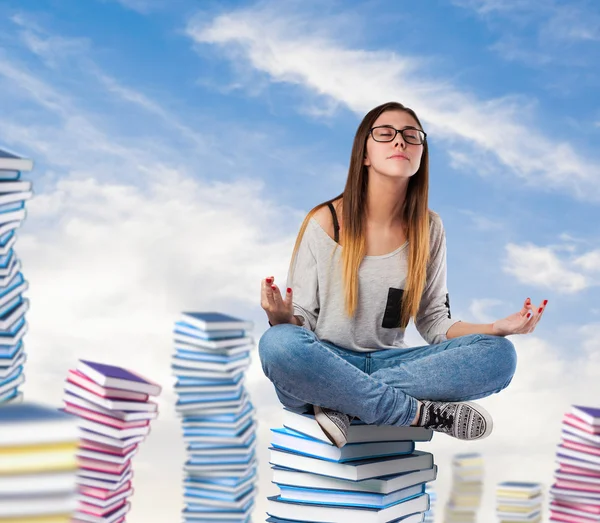 Giovane donna seduta sulla torre dei libri — Foto Stock