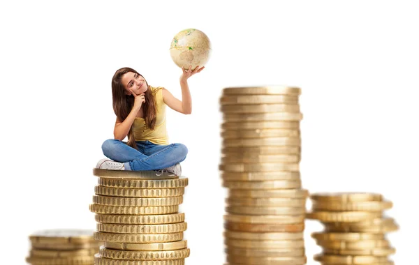 Young woman sitting on coins tower — Stock Photo, Image