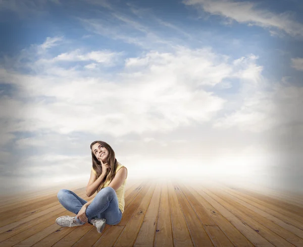 Pretty woman sitting on wooden floor — Stock Photo, Image