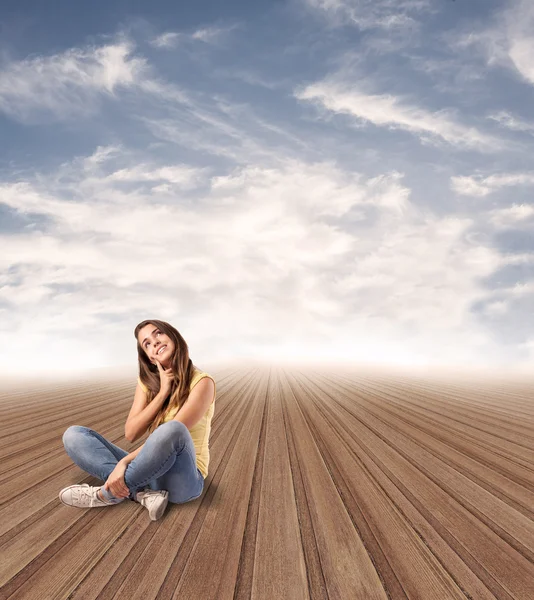 Pretty woman sitting on wooden floor — Stock Photo, Image