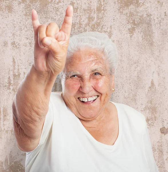 Alte Frau zeigt Rock-Symbol — Stockfoto