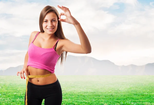 Sporty young girl measuring weight — Stock Photo, Image