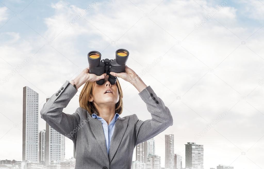 Executive young woman with binoculars