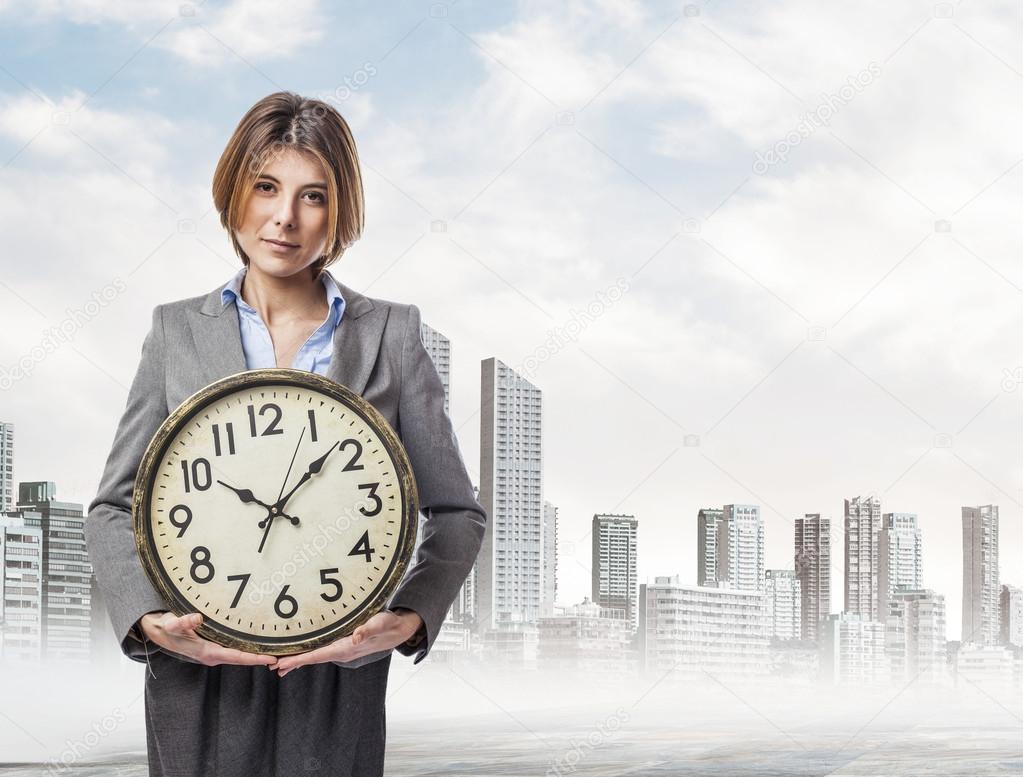 Young woman holding big clock