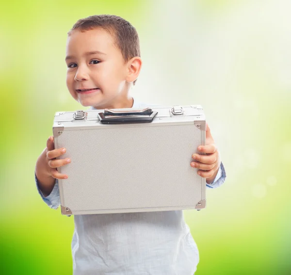 Niño sosteniendo maletín pesado — Foto de Stock