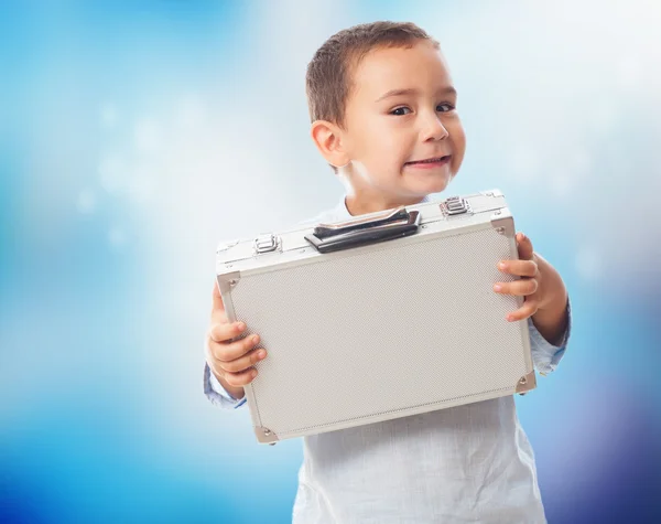 Niño sosteniendo maletín pesado — Foto de Stock