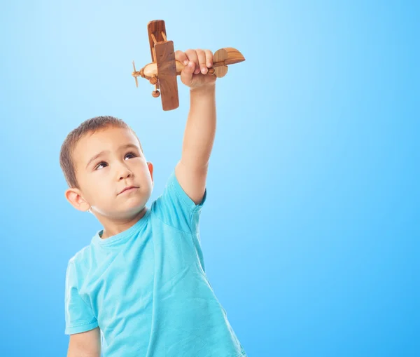 Little boy playing with wooden plane — Stock Photo, Image