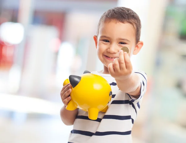 Pequeño niño poniendo dinero en Piggybank — Foto de Stock