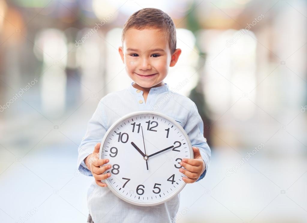 Little boy holding clock