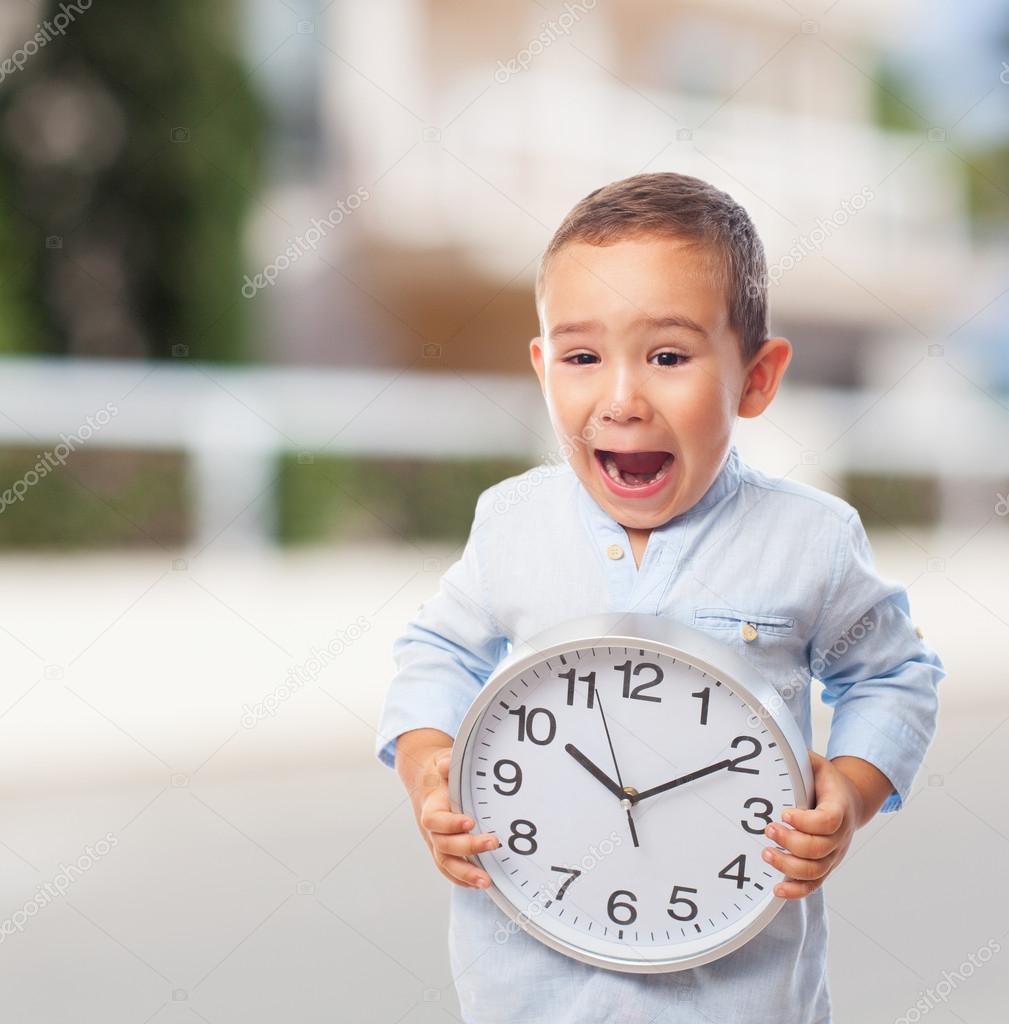 Little boy holding clock