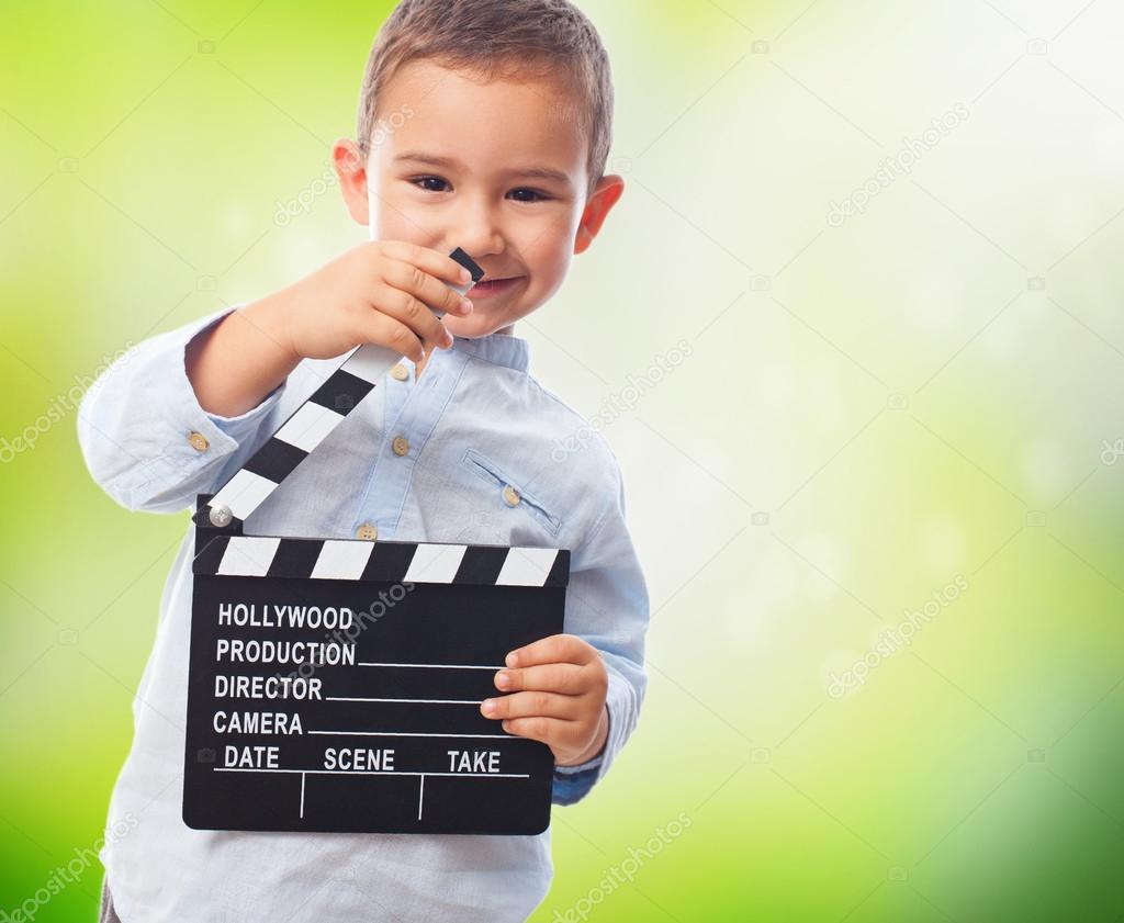 Little boy holding clapper board