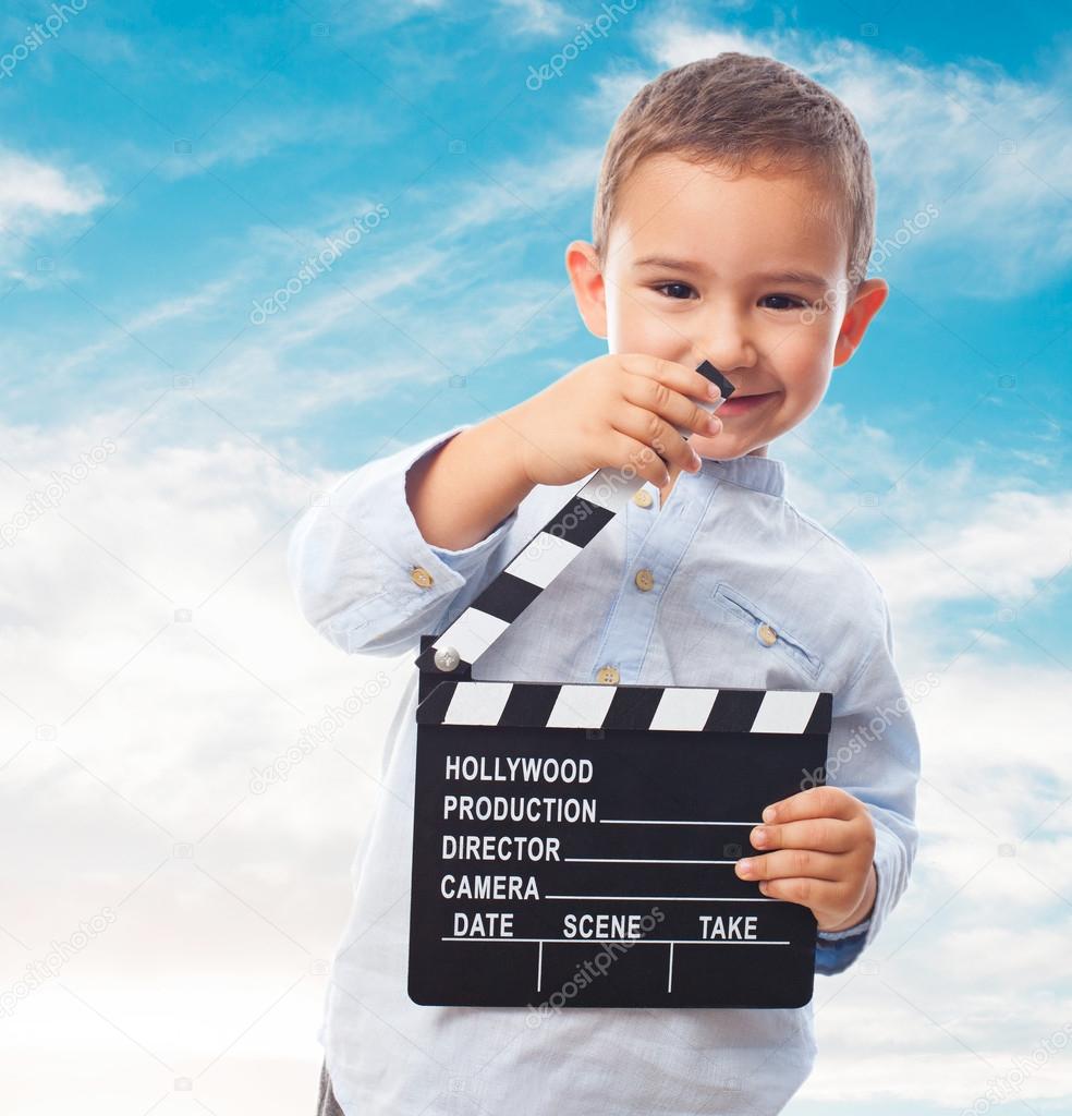 Little boy holding clapper board