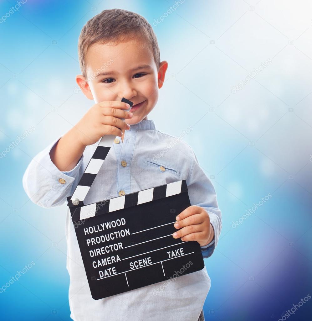 Little boy holding clapper board