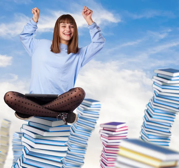 Jonge vrouw winnaar zittend op boeken — Stockfoto