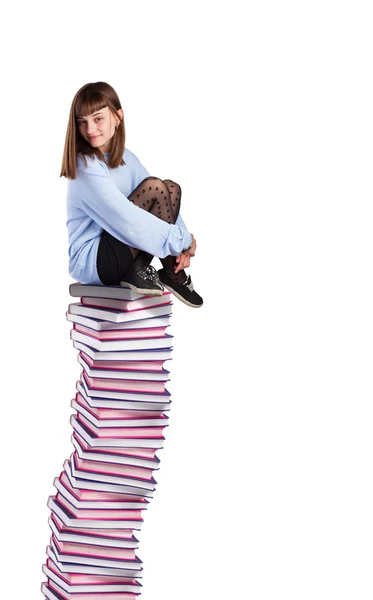 Mujer joven sentada en la pila de libros — Foto de Stock