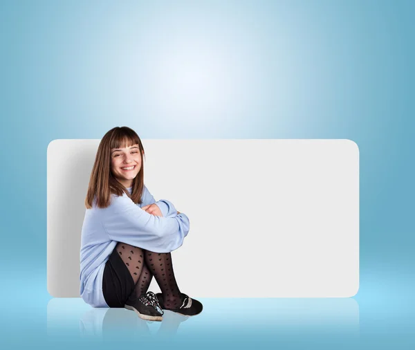 Afiş ile oturan genç kadın — Stok fotoğraf