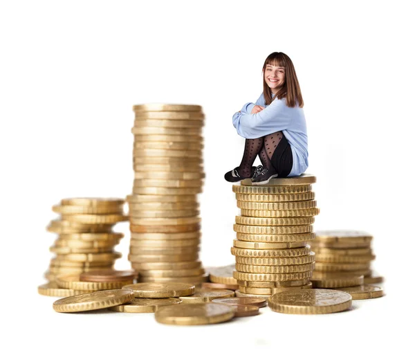 Young woman sitting on coins tower — Stock Photo, Image
