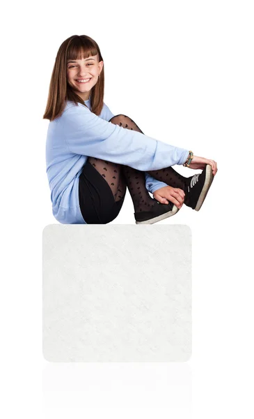 Young woman sitting on white box — Stock Photo, Image