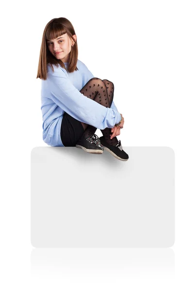 Young woman sitting on white box — Stock Photo, Image
