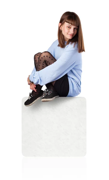 Mladá žena, sedící na bílém poli — Stock fotografie