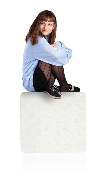 Beyaz kutu üzerinde oturan genç kadın — Stok fotoğraf