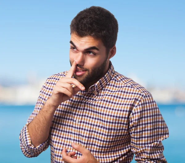 Young man with finger into nose — Stock Photo, Image