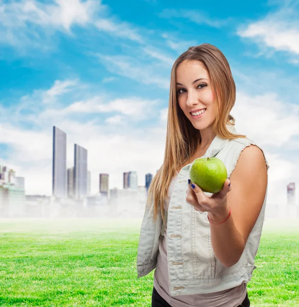 Pretty young woman offering apple — Stock Photo, Image