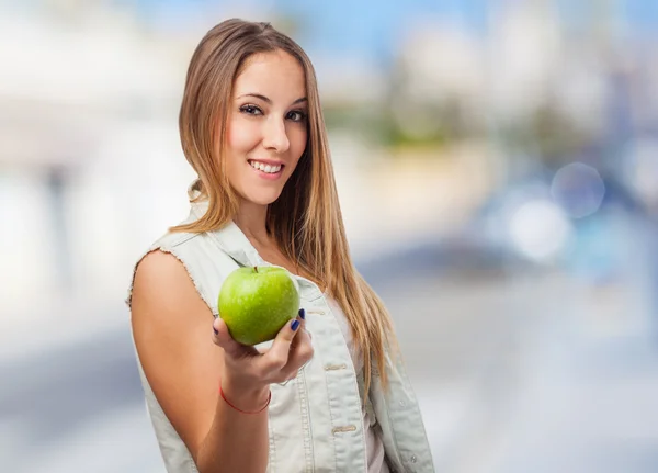 Гарненька молода жінка пропонує яблуко — стокове фото
