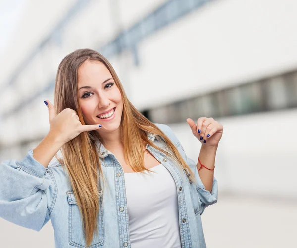 Mujer joven haciendo gesto para llamar — Foto de Stock