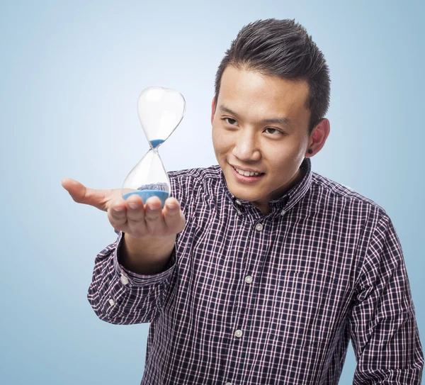 Young asian man with sand timer — Stock Photo, Image