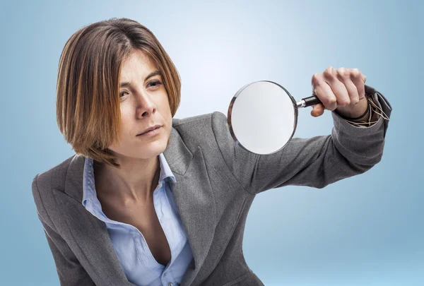 Uitvoerend jonge vrouw met Vergrootglas — Stockfoto