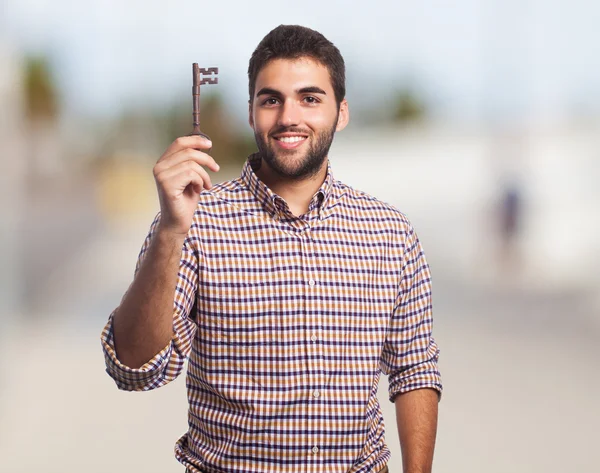 Young man holding old key — Stock Photo, Image