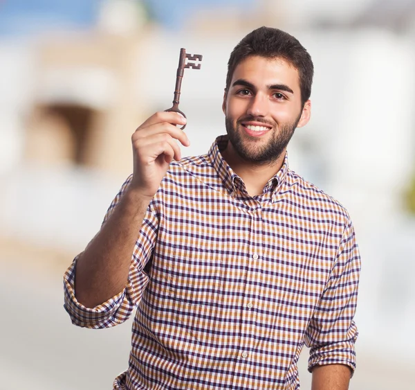 Young man holding old key — Stock Photo, Image