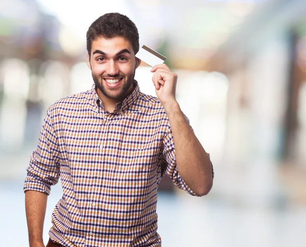 Jovem segurando cartão de crédito — Fotografia de Stock