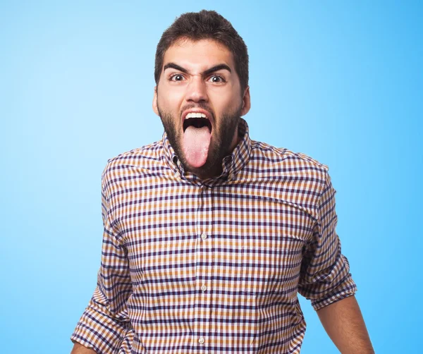 Young man showing his tongue — Stock Photo, Image