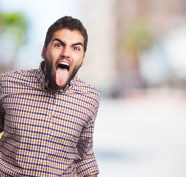 Young man showing his tongue — Stock Photo, Image