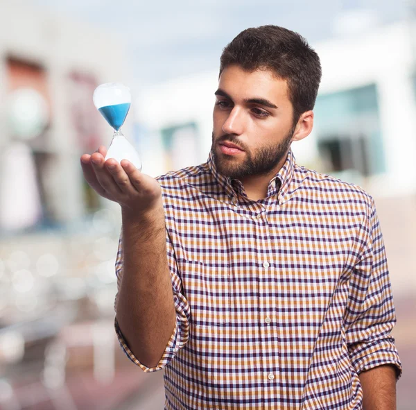 Genç adam holding kum zamanlayıcı — Stok fotoğraf