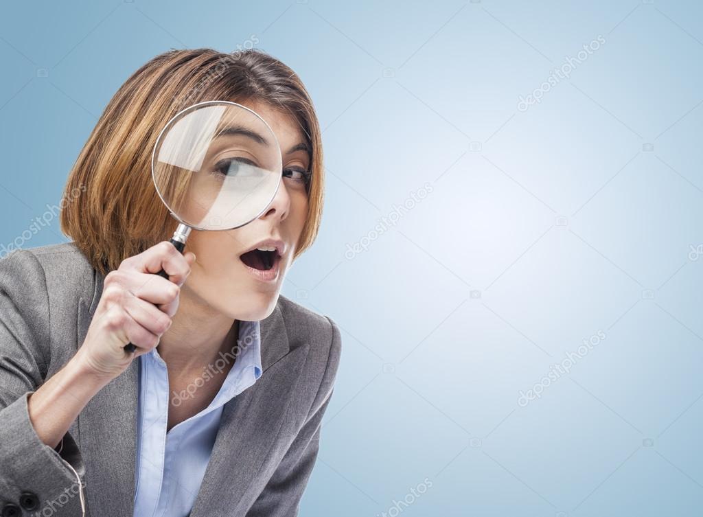 Woman looking through magnifying glass