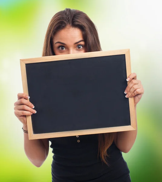 Studentin versteckt sich hinter einer Tafel — Stockfoto