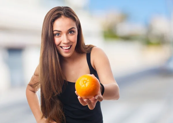 Chica sosteniendo una naranja —  Fotos de Stock