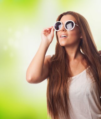 Yuvarlak bir güneş gözlüğü takmış kız