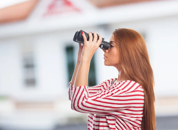 Frau blickt durch ein Fernglas — Stockfoto