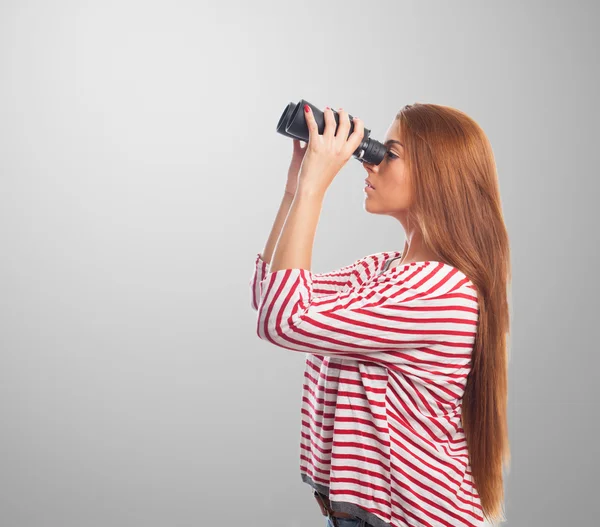 Mujer mirando a través de un prismáticos — Foto de Stock