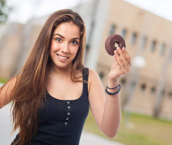 Femme tenant un beignet au chocolat — Photo