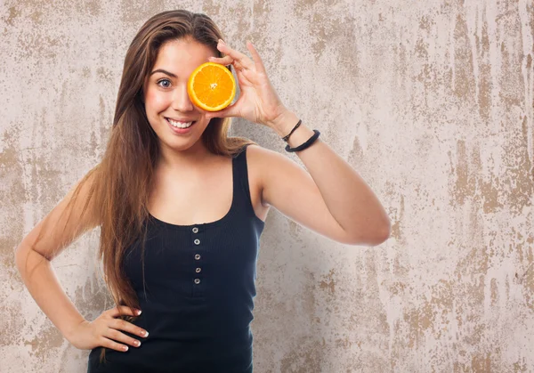 Chica sosteniendo una rebanada de naranja —  Fotos de Stock