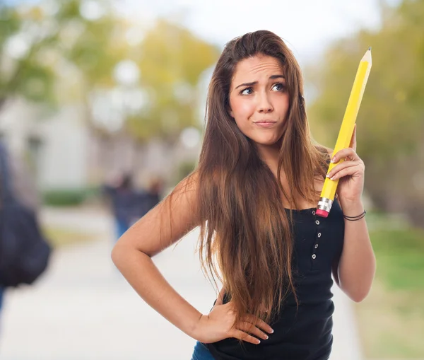 Estudiante sosteniendo un lápiz y pensando en —  Fotos de Stock