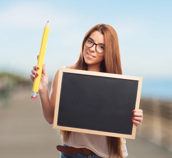 Student holding a chalkboard and a pencil — Stock Photo, Image